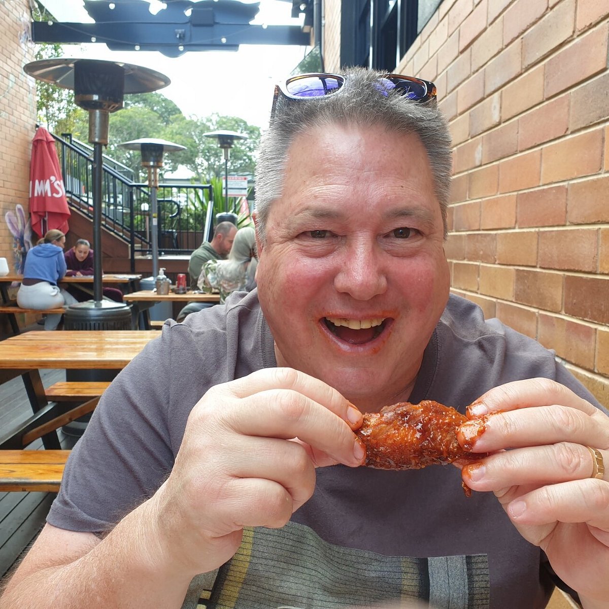 A fan tucking into a King Of The Wings chicken wing